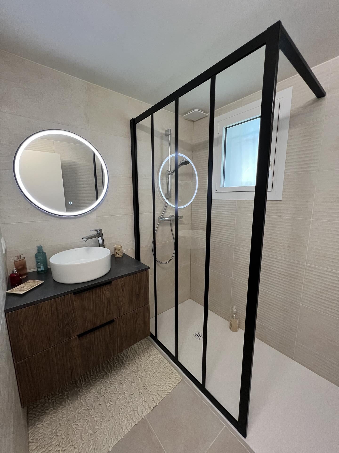 Salle de bain avec douche vitrée et meuble vasque en bois